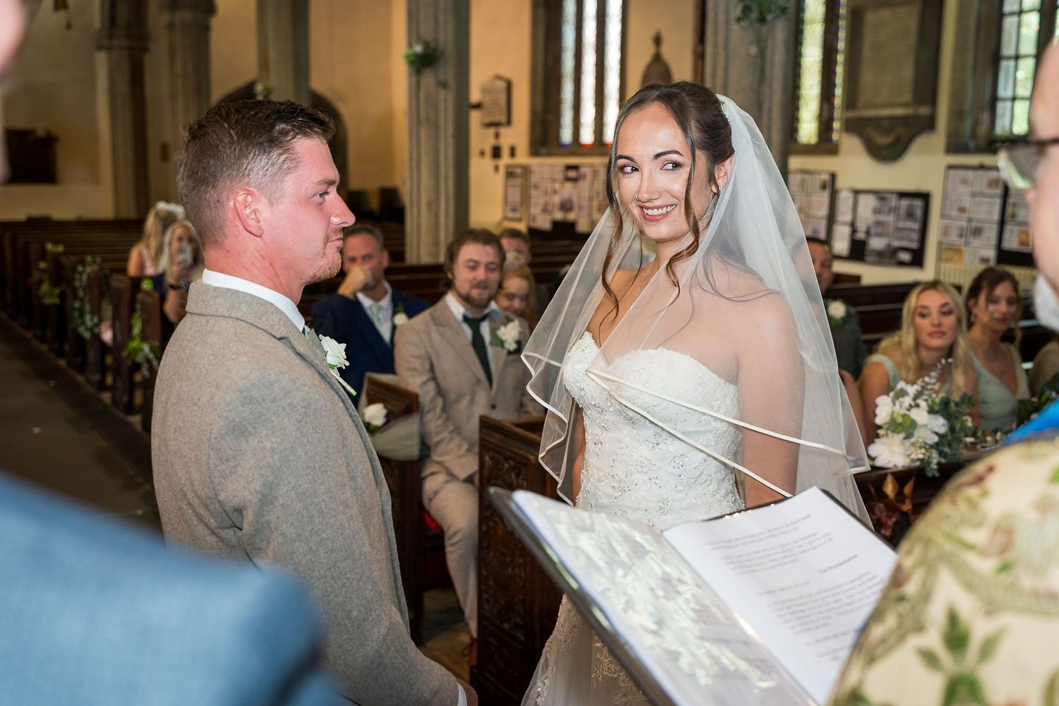 A couple exchanges vows during their wedding ceremony inside a beautiful historic church.