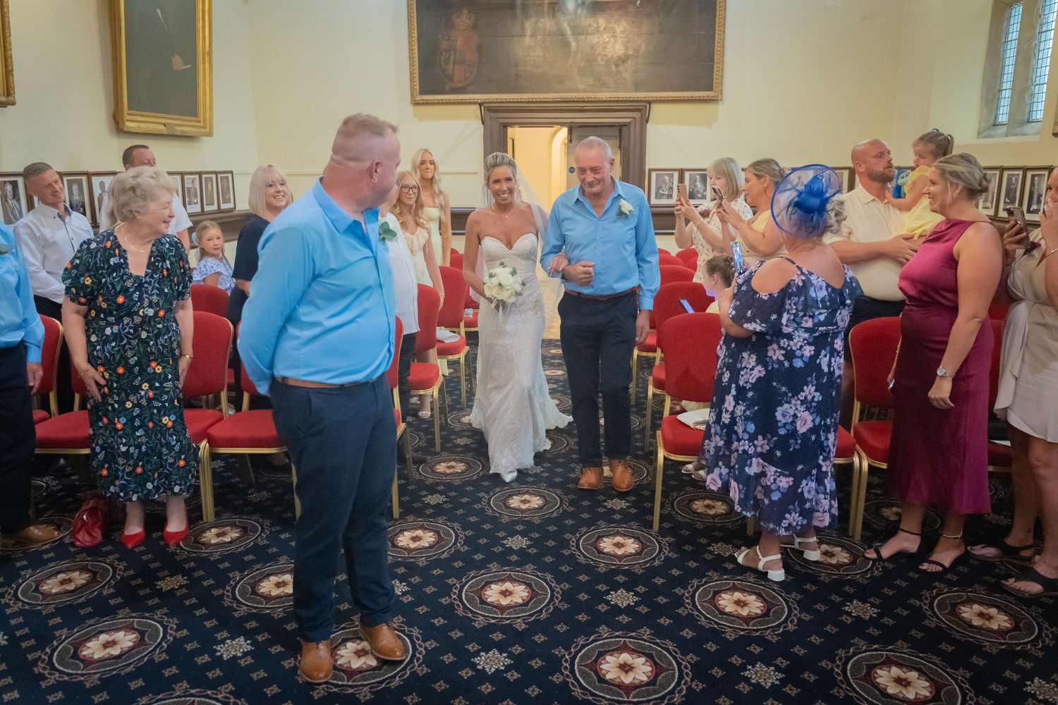 Group of seniors dancing and socializing together at a community event in a carpeted banquet hall.