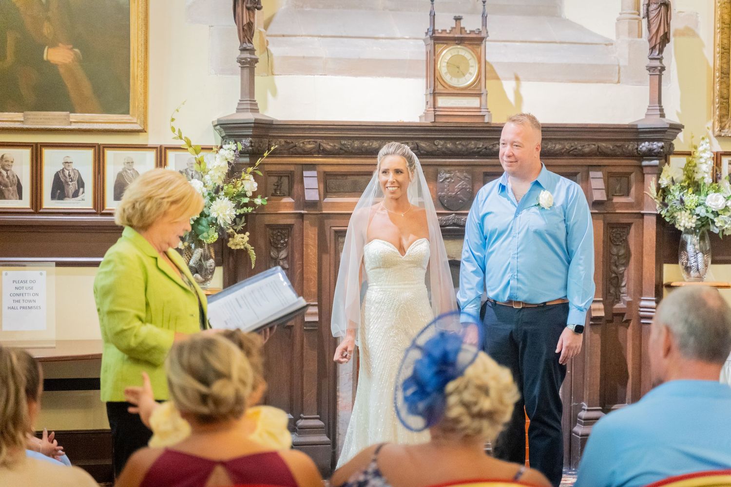 A couple exchanges vows during a traditional church wedding ceremony surrounded by floral decorations.