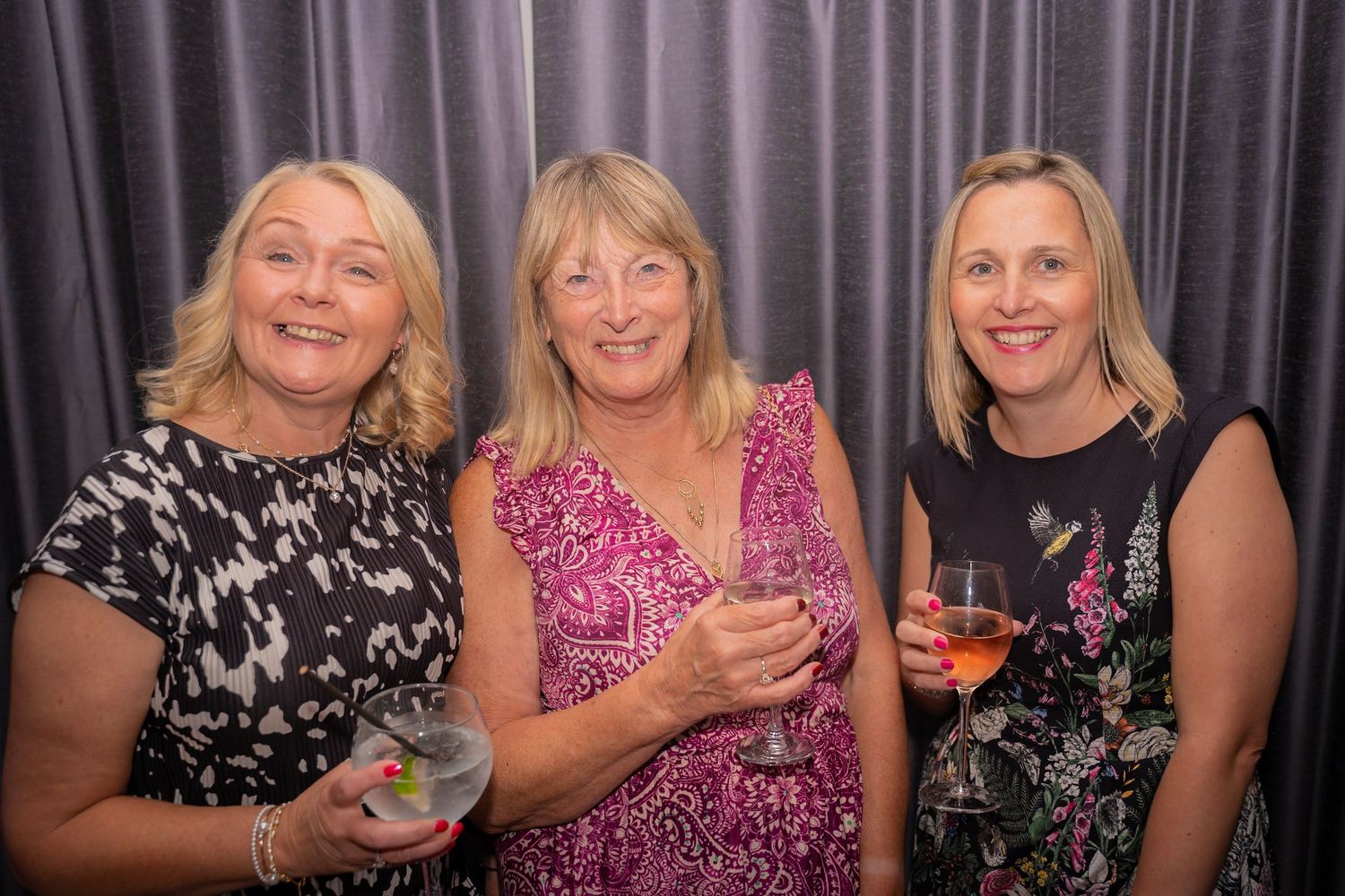 Group celebration photo with colorful party decorations and evening attire.