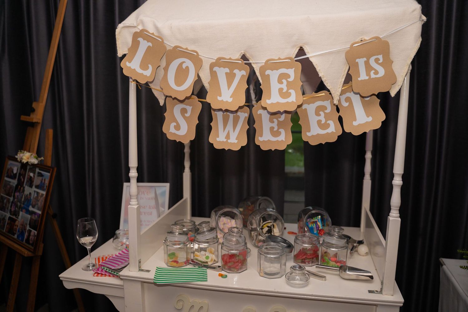 White fabric banner decorations with text hanging against a dark background at an event.