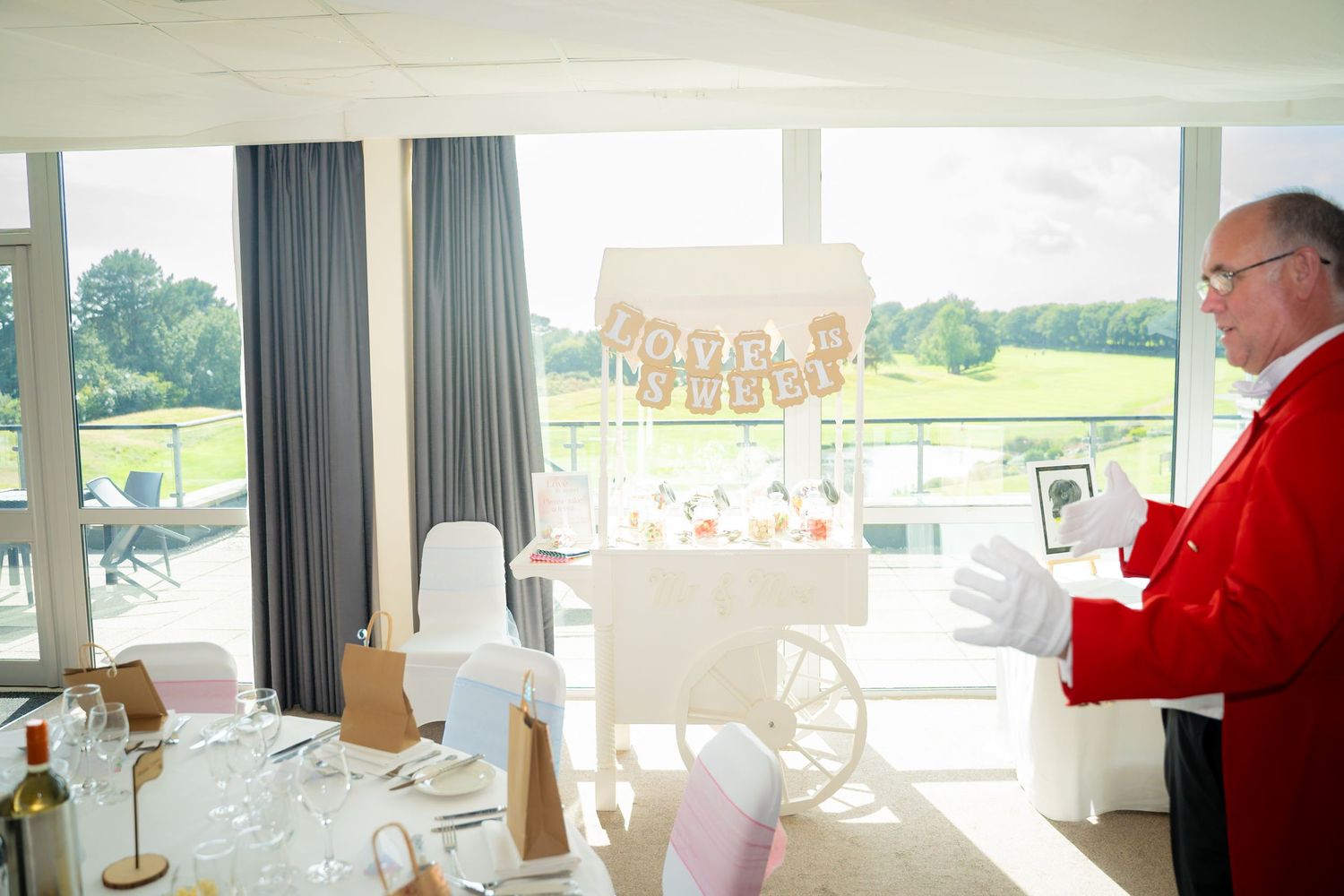 Elegant white reception room with panoramic windows overlooking a scenic countryside view.