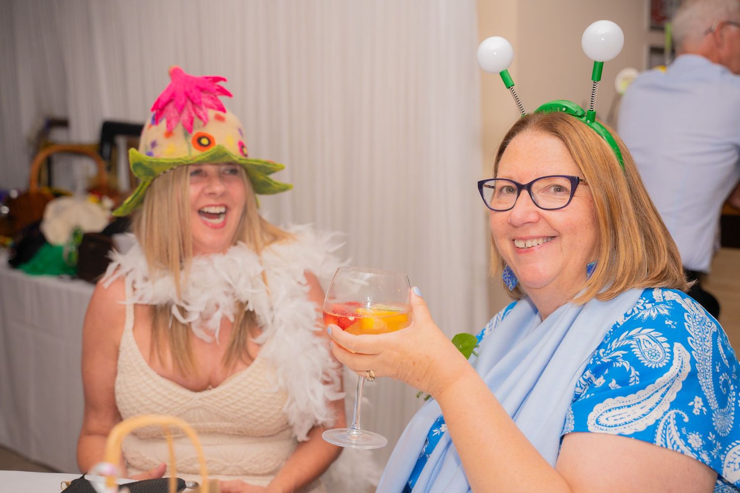 Wedding reception celebration with guests enjoying drinks and conversation at decorated tables.