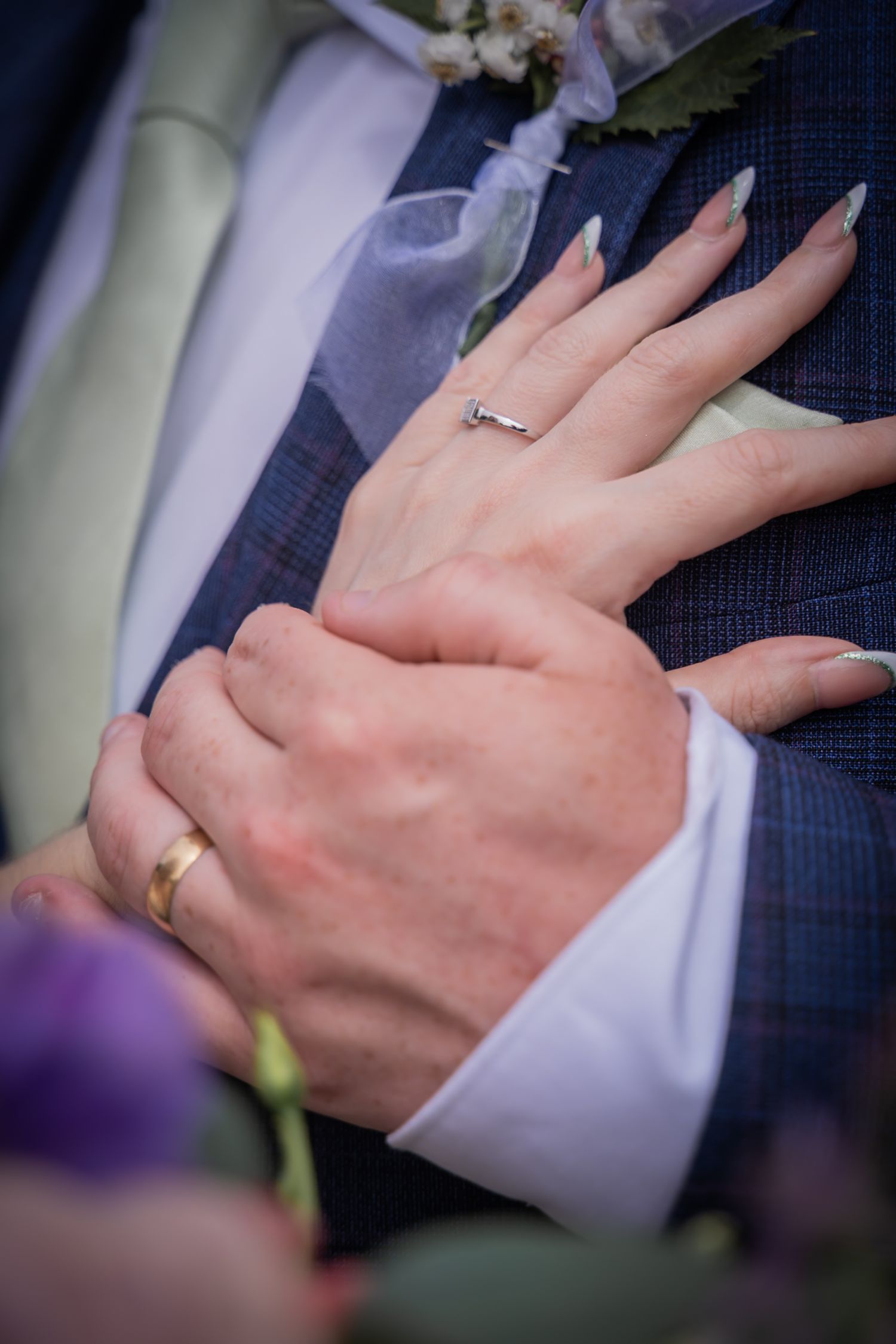 Close-up detail shots of wedding rings and hands during an intimate wedding ceremony moment.