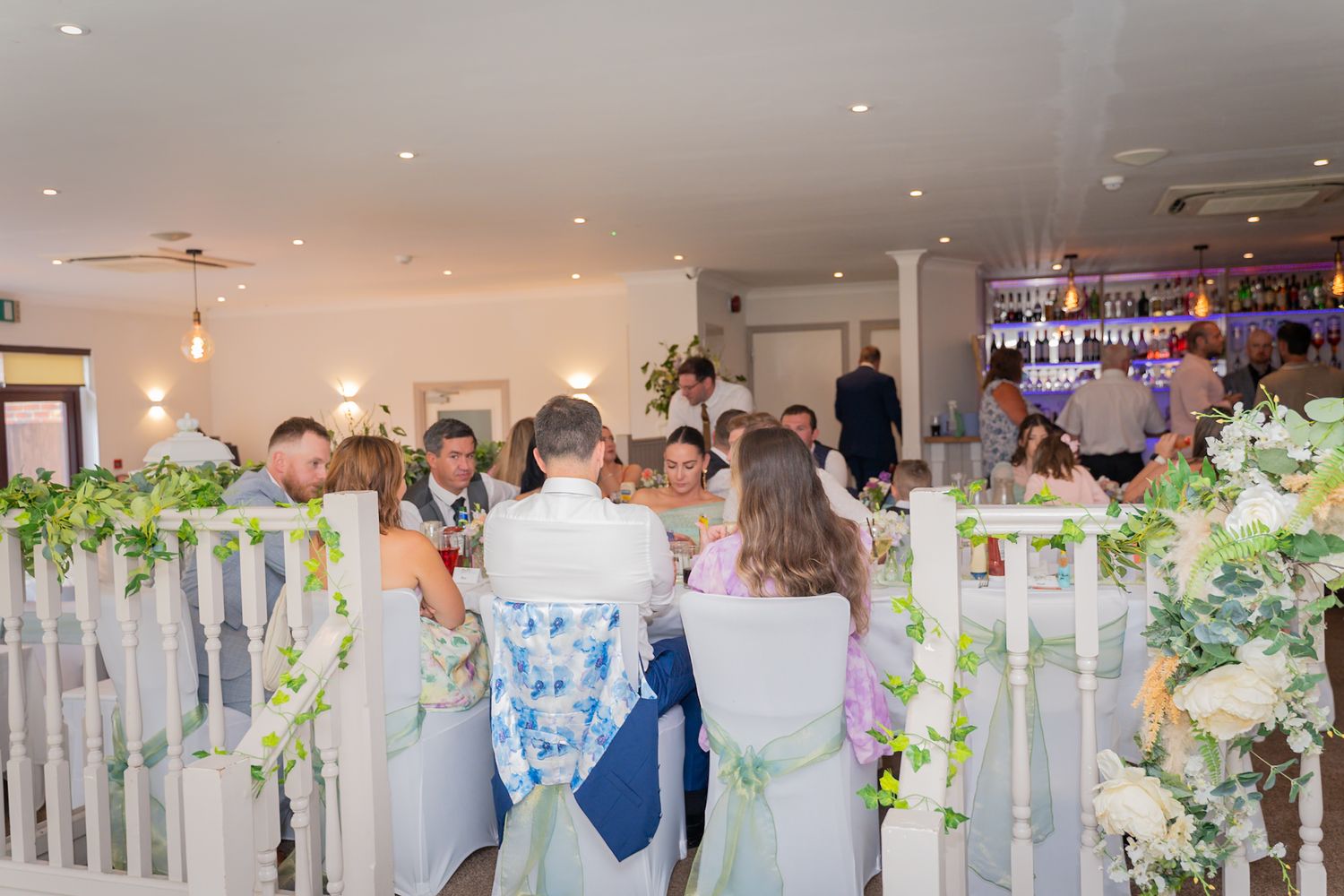 Wedding reception venue decorated with elegant lighting and white decor for a celebration.