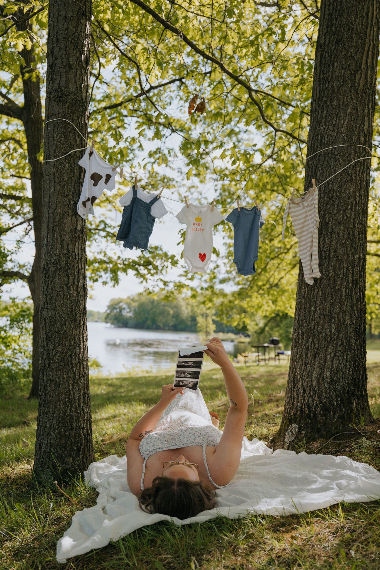 Magical forest clearing decorated with hanging red and blue hearts while someone relaxes on a white blanket.