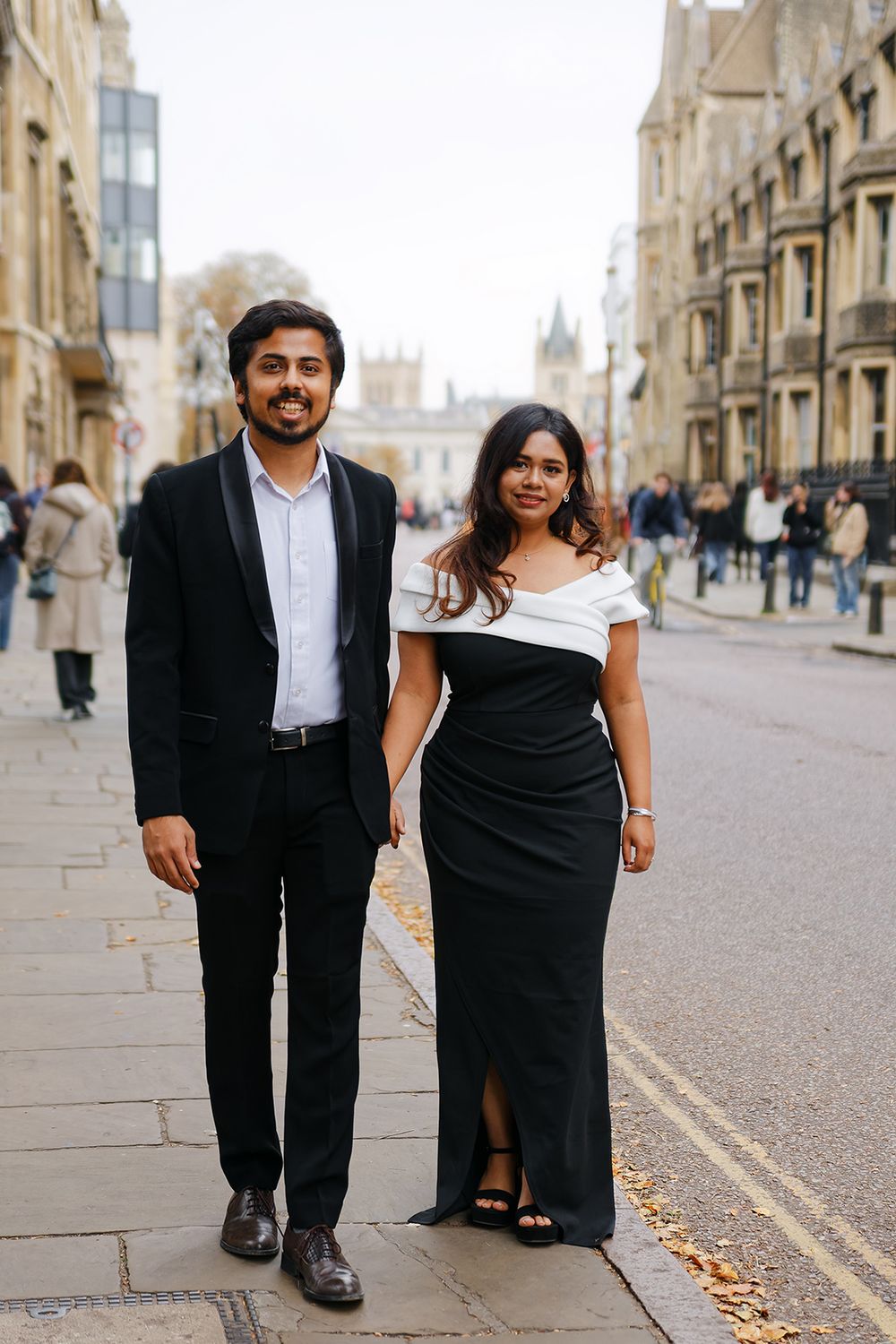 Couple walking through historic Cambridge streets during an elegant engagement photoshoot.