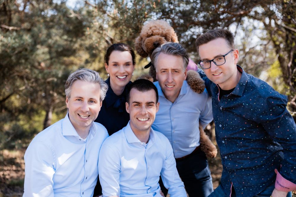 A series of five casual outdoor family photos showing joyful group poses in light blue shirts against a natural backdrop.