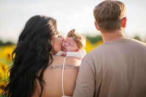 A couple shares a tender moment together in a sunlit field of yellow flowers during a romantic photoshoot.