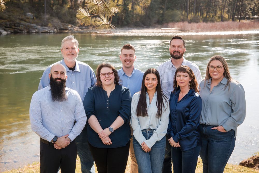 Team members collaborating at the riverfront office, showcasing teamwork against a scenic riverside backdrop.