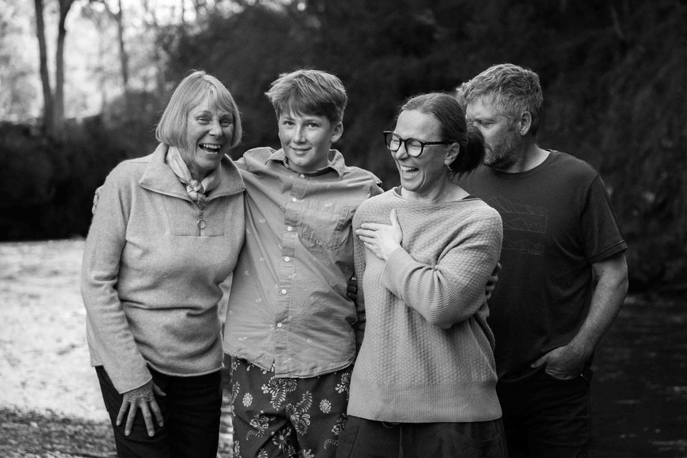 Black and white photo series showing joyful family members embracing and laughing together outdoors.