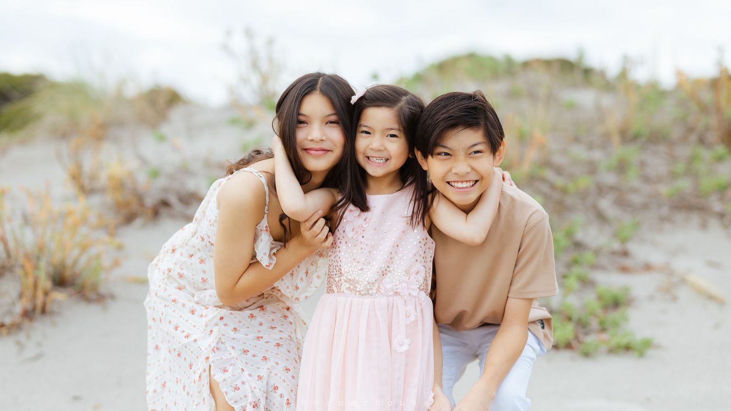 A family in casual clothes enjoys quality time together walking and playing on a peaceful beach at sunset.