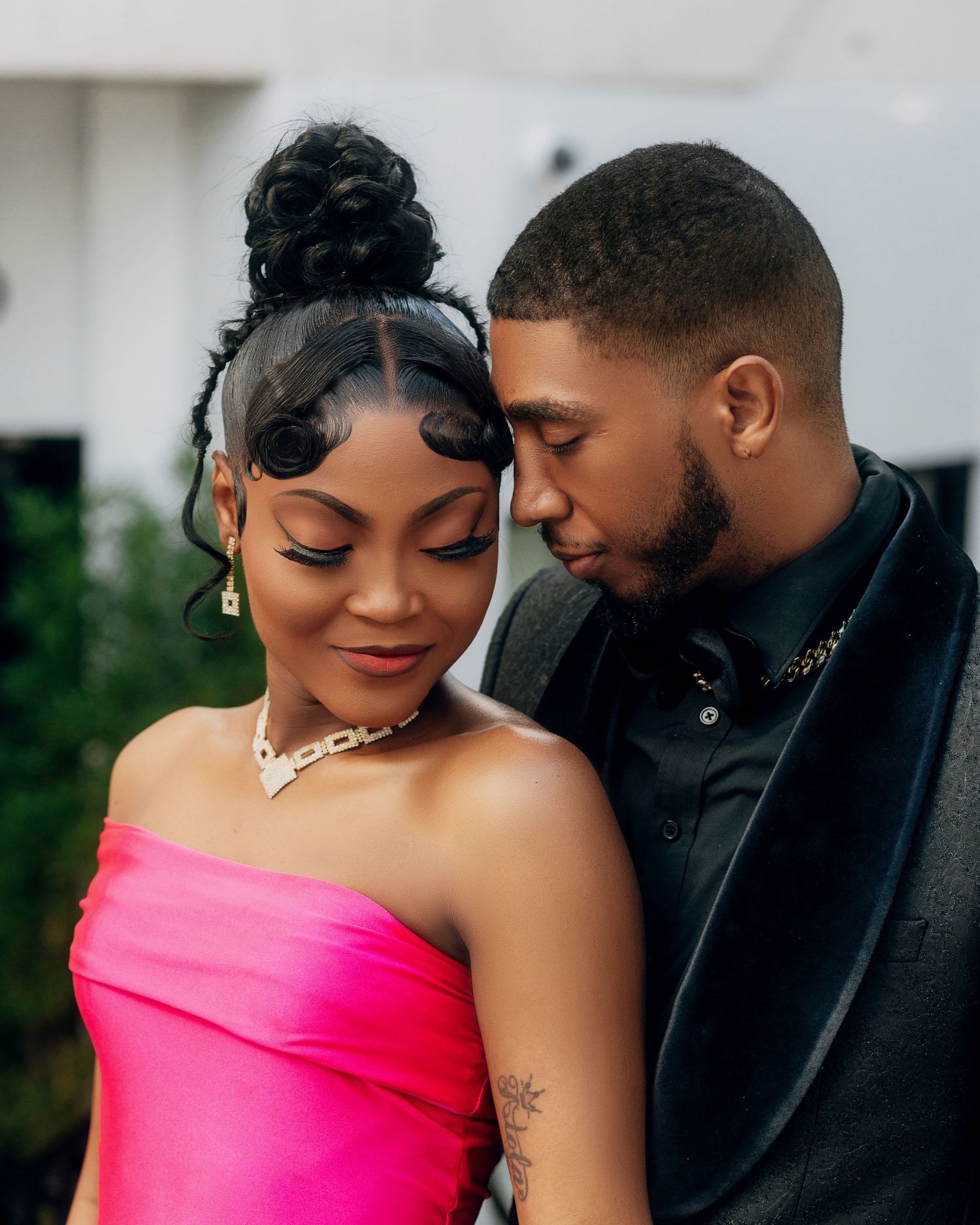 Intimate portrait of couple in formal wear with pink gown and black suit jacket.