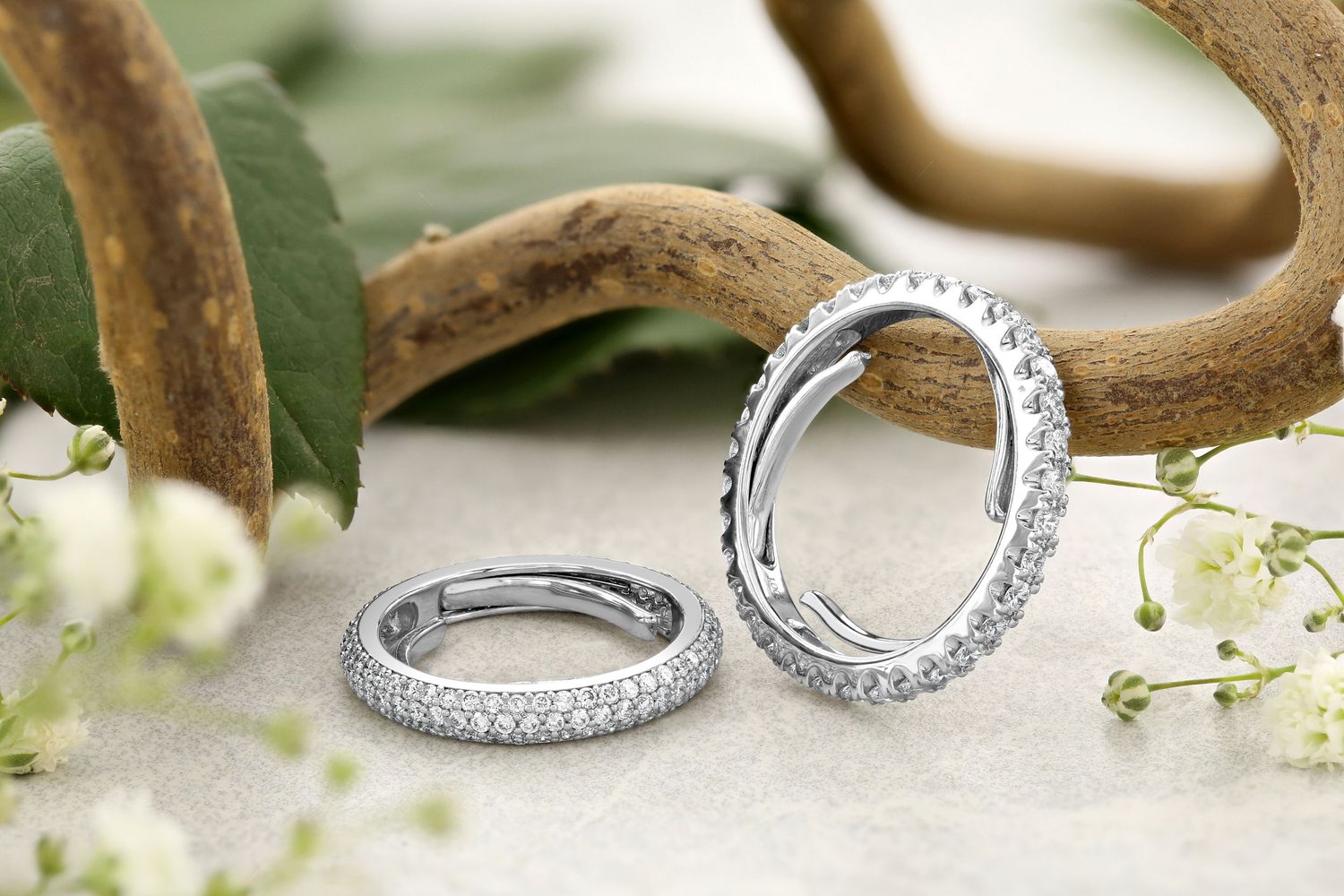 Two diamond eternity rings displayed with antlers and baby's breath flowers.