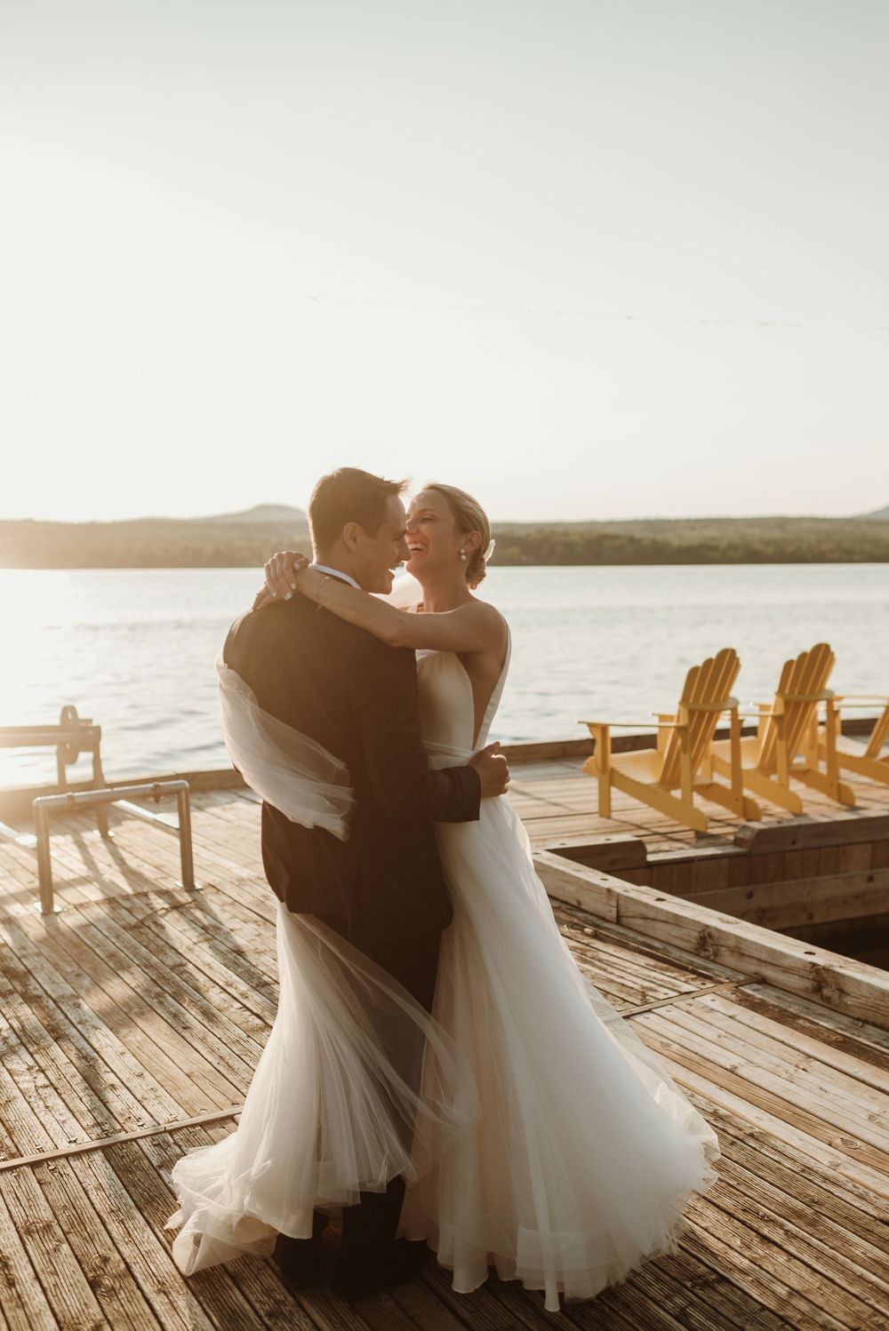 Photo de mariage au coucher du soleil au Golf privé Hermitage à Magog – couple de mariés dansant sur un quai en bois avec vue sur le lac