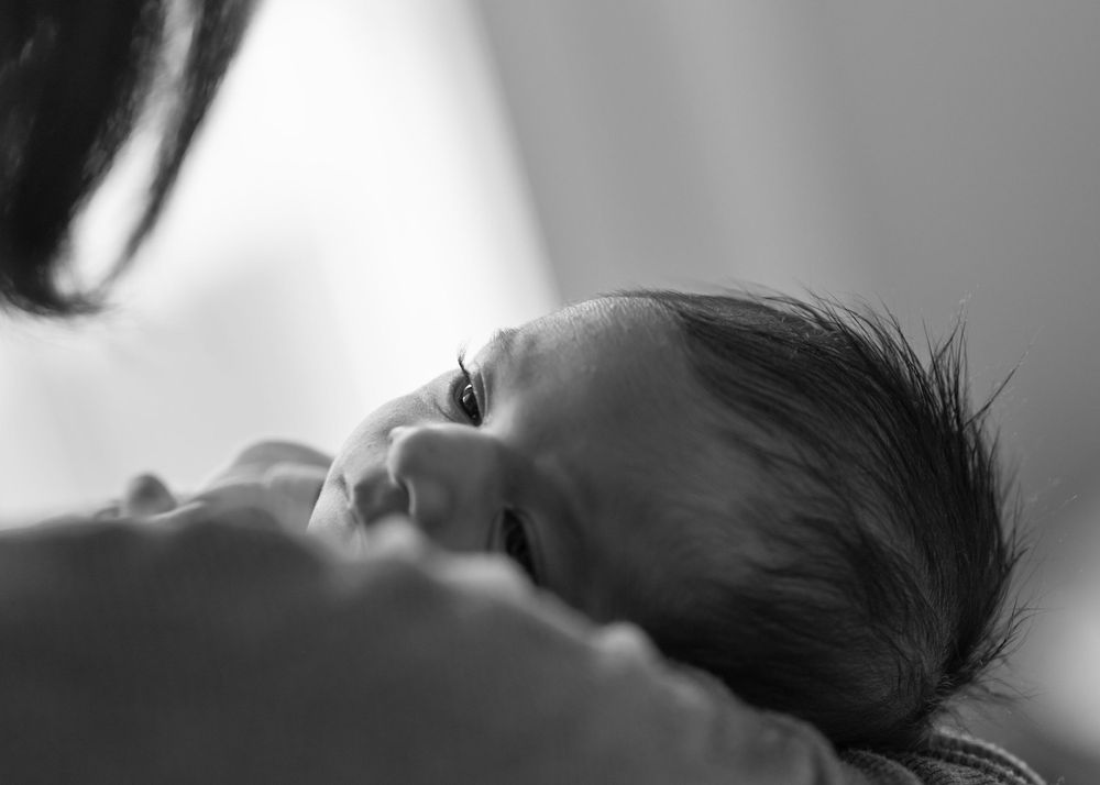 Intimate black and white side profile of sleeping newborn.