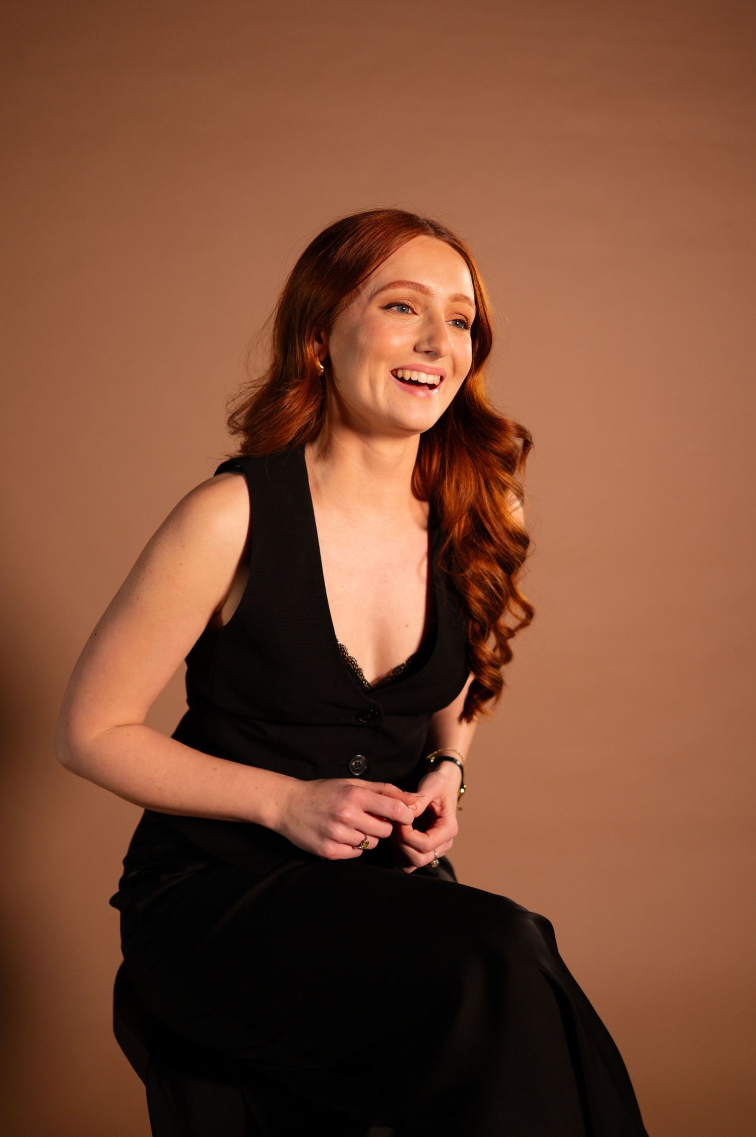 portrait of bon amour weddings owner Megan Strange sitting and smiling wearing all black