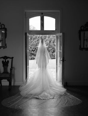A wedding dress is displayed in silhouette against natural light streaming through a window in a series of black and white images.