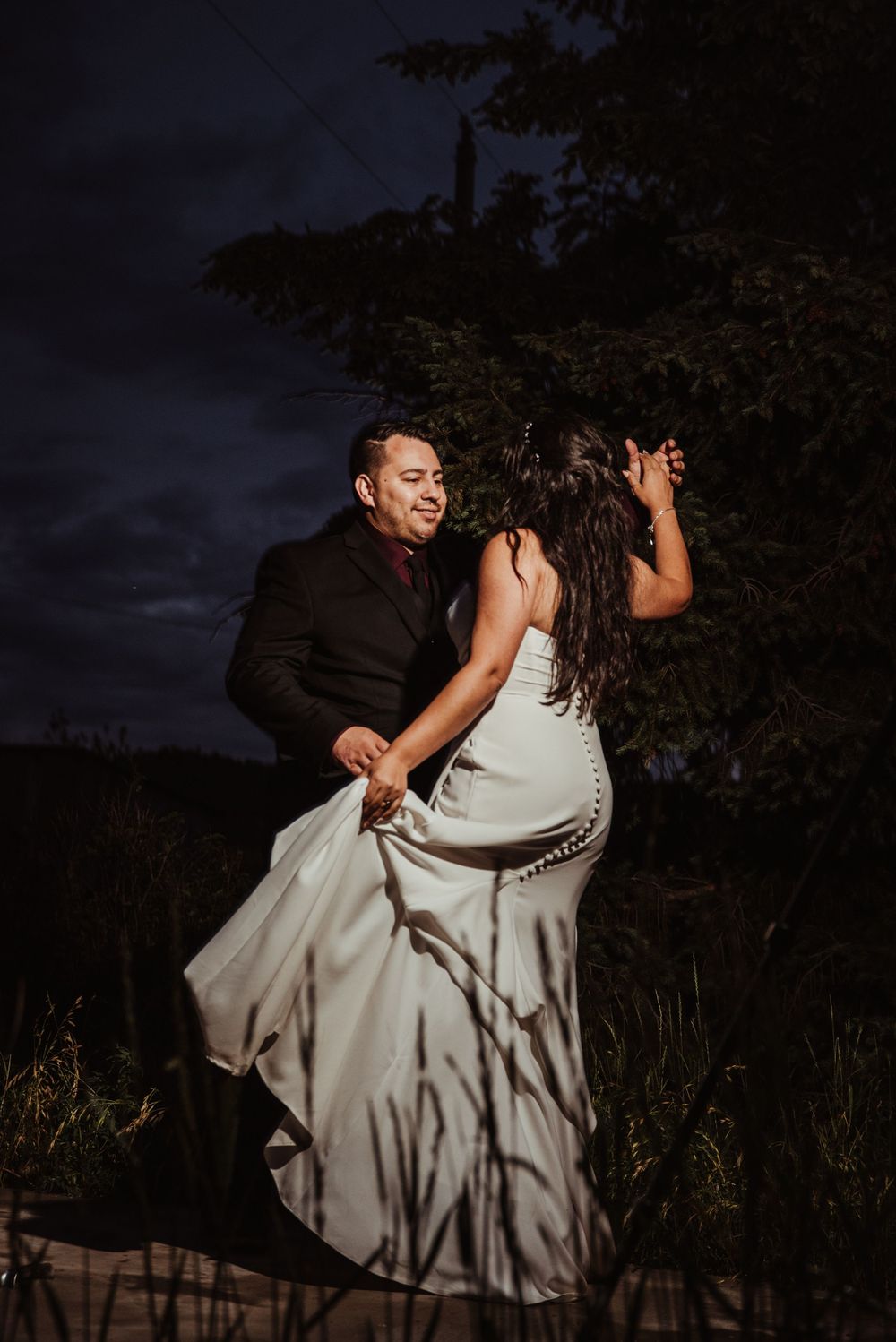 Bride and Groom share their first dance amidst a dark nighttime landscape