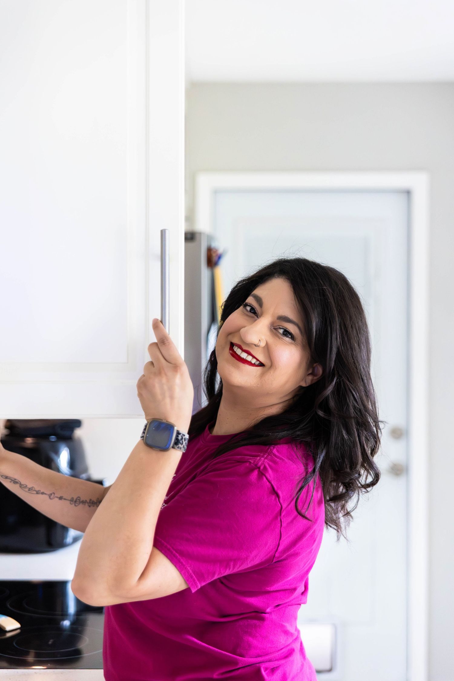 A woman organizing a home smiles for the camera.