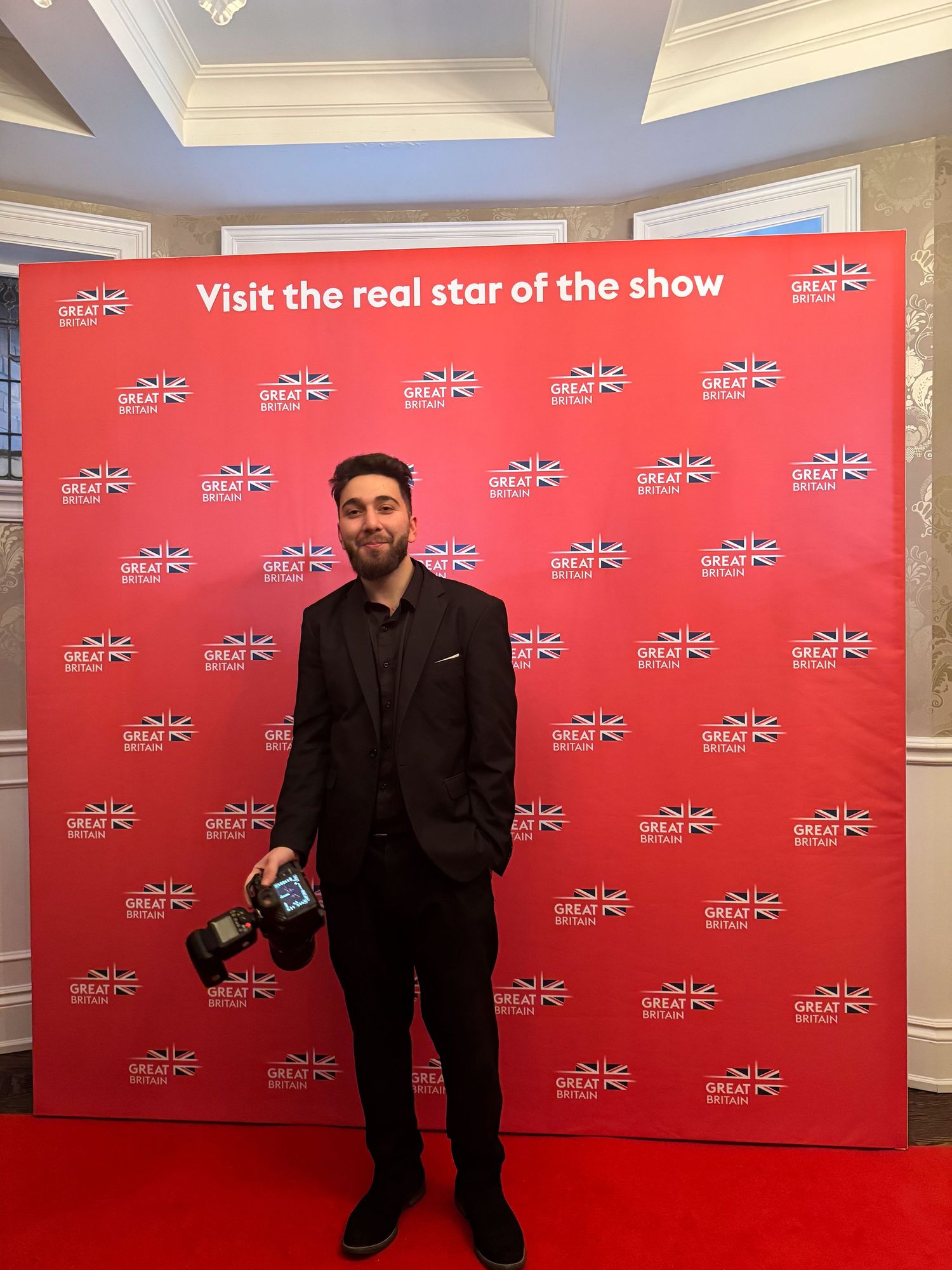 photo of the photgrapher standing infront of the backdrop