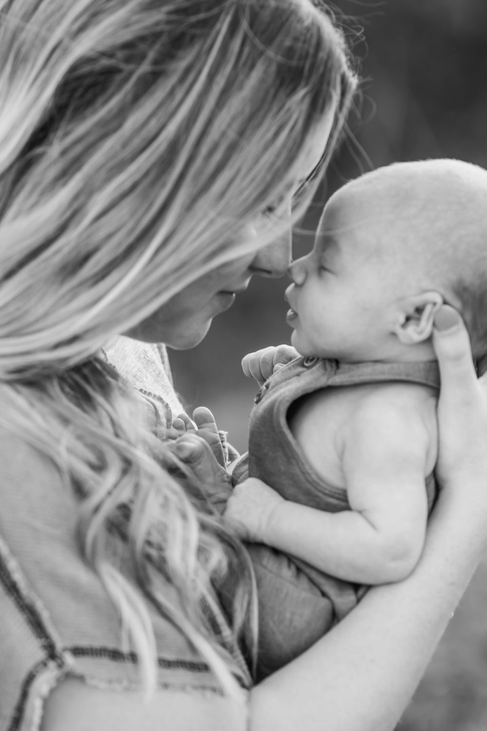 Black and white portrait of tender moment between mother and infant.