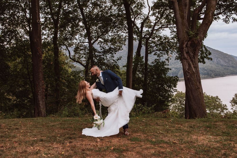 Bride and groom dip moment at West Point, New York wedding overlooking Hudson River and Mountains