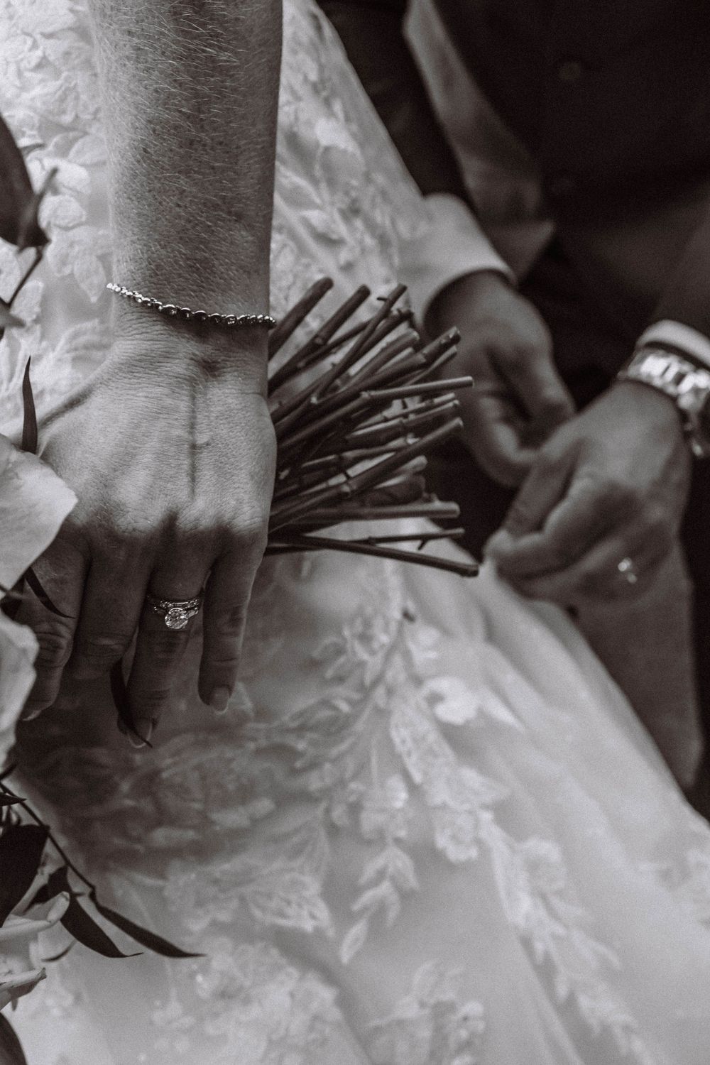 Groom bustling brides dress detail of ring and flowers at West Point wedding