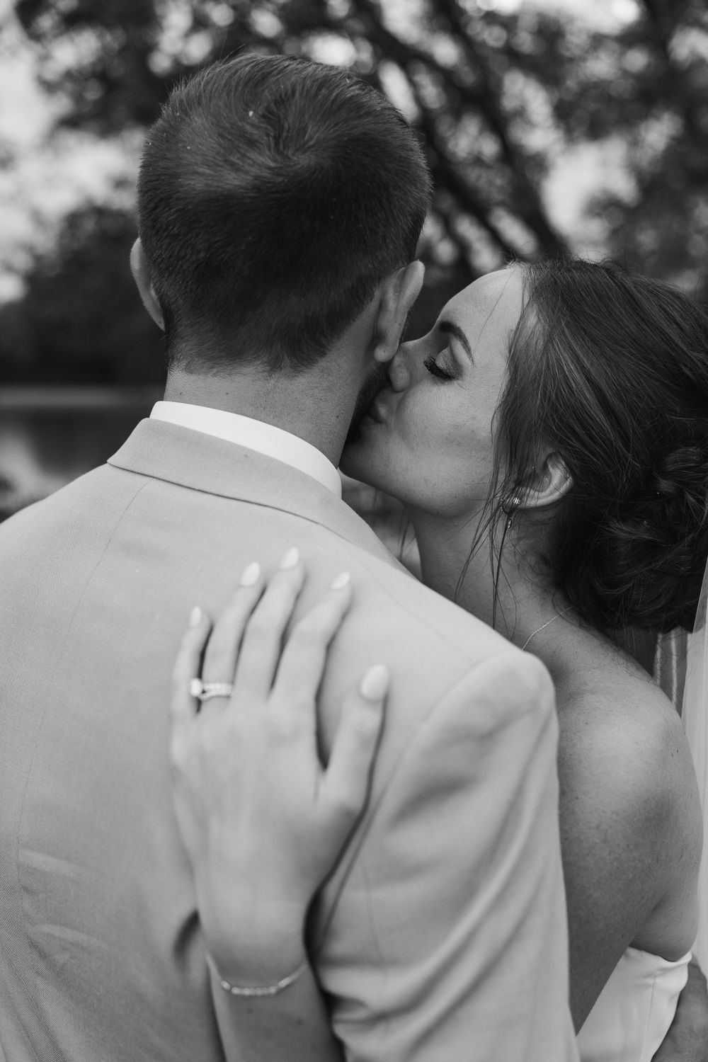 Intimate black and white wedding portrait showing ring and tender embrace.
