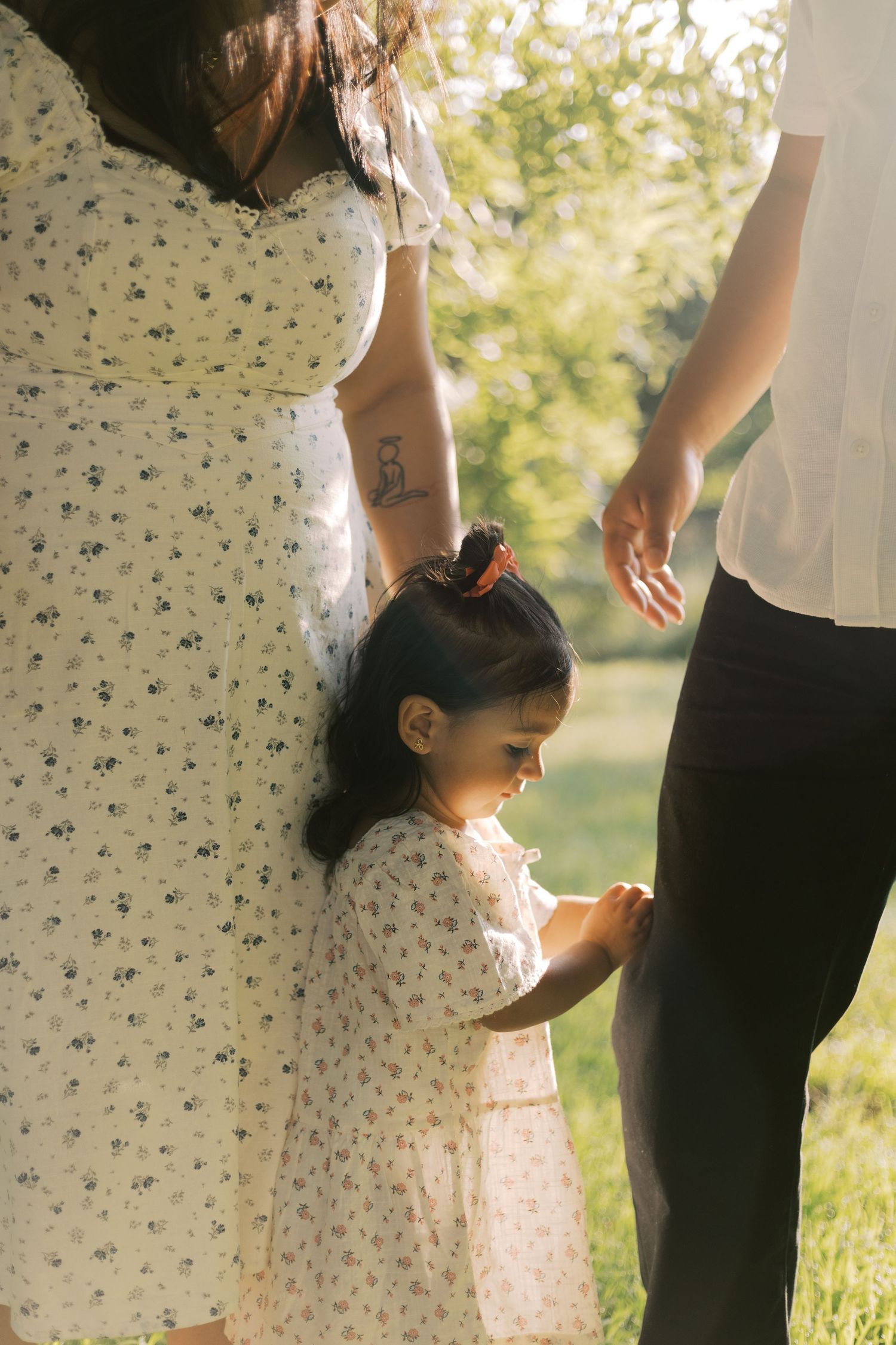 Someone lifts a child while standing in a golden field at sunset.
