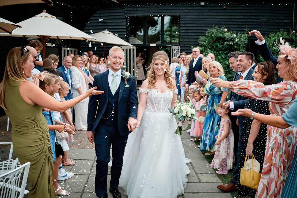 Guests throw confetti over the newlyweds during an outdoor celebration.