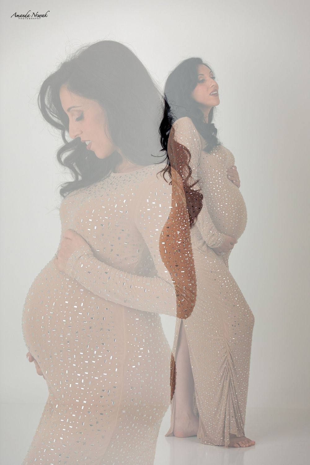 Artistic double exposure maternity photo of a woman in a sparkly gown against a white background.