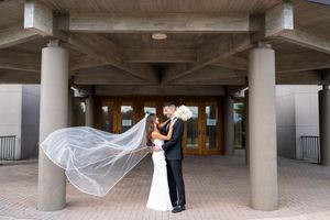 Modern architectural wedding venue with concrete pillars and covered walkway.