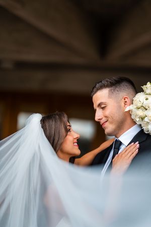 Artistic wedding photography sequence captured through flowing veil in covered venue.