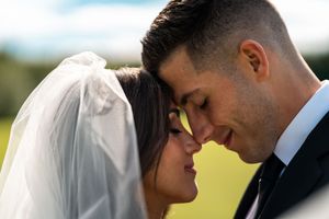 Romantic wedding couple portraits showing tender moments against natural outdoor backdrop.