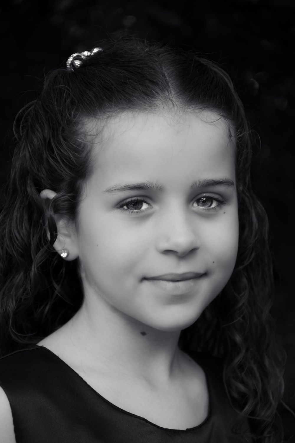 Black and white portrait with curly hair and pearl hair accessories.