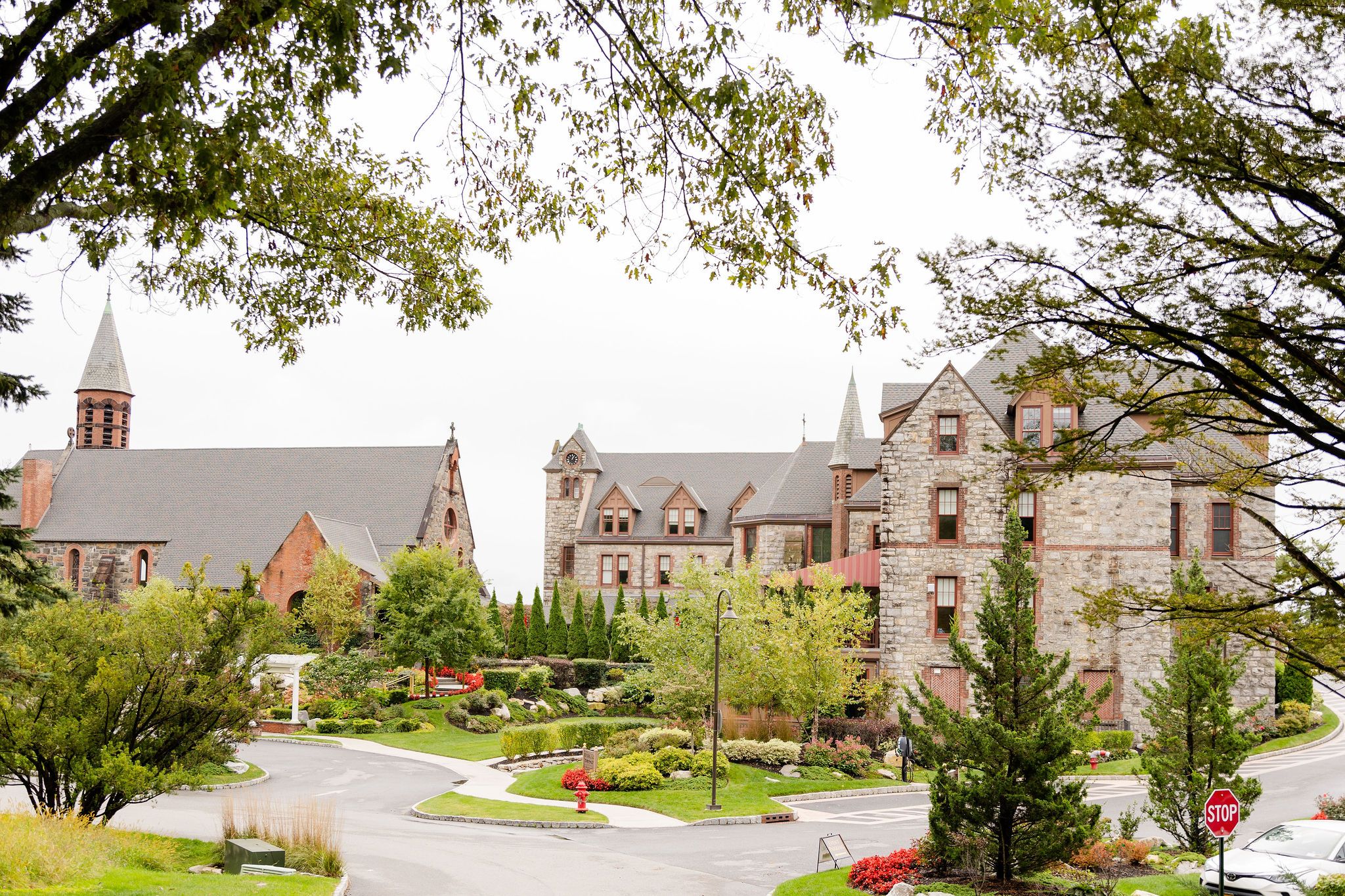 Stone gothic architecture of a church campus with manicured gardens and walkways.