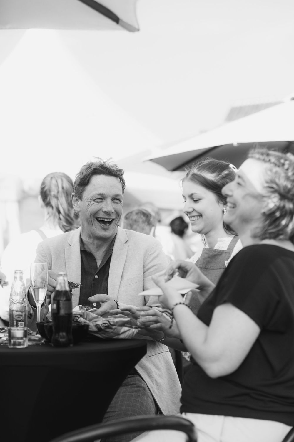 Lachende mensen tijdens een communiefeest.