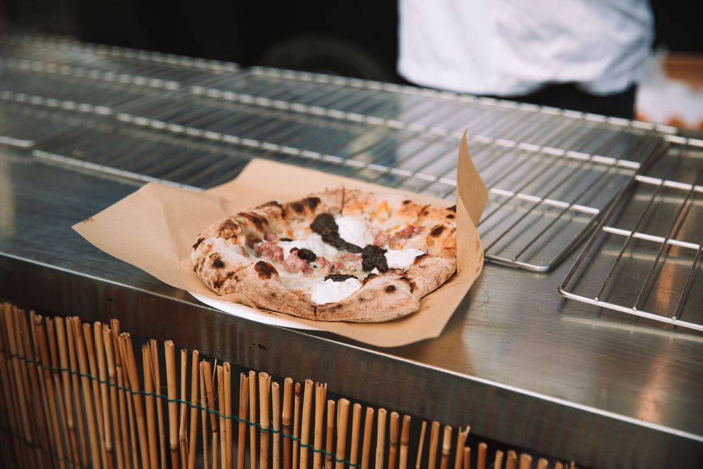 Foodtruck die overheerlijke pizza's maakt tijdens een communiefeest.