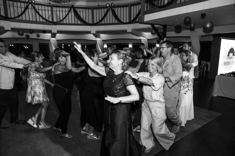 Zwart-witfoto van koppels die enthousiast dansen tijdens een sfeervol 50ste verjaardagsfeest.