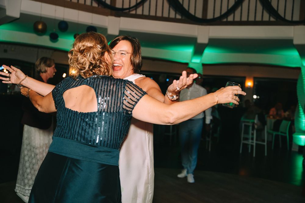 Twee vrouwen dansen enthousiast tijdens een verjaardagsfeest.