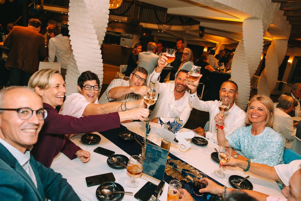 Gasten heffen het glas op het jarige koppel tijdens hun 50ste verjaardagsfeest in De Meerhoek in Ledegem.