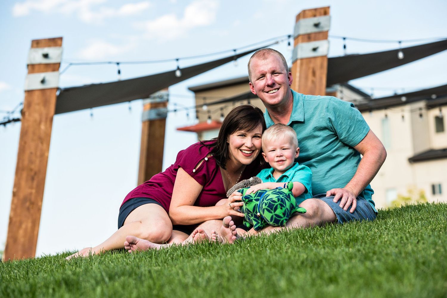 A family of three in front of a fence with the mountains in the background