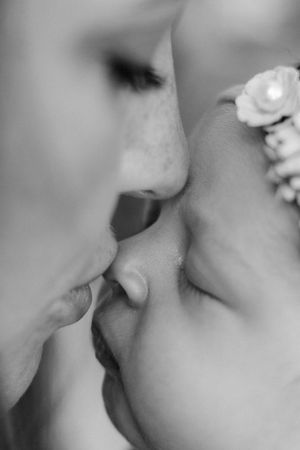 mama kissing baby nose close up in black and white
