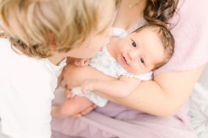 baby girl looking up at the camera in moms arms