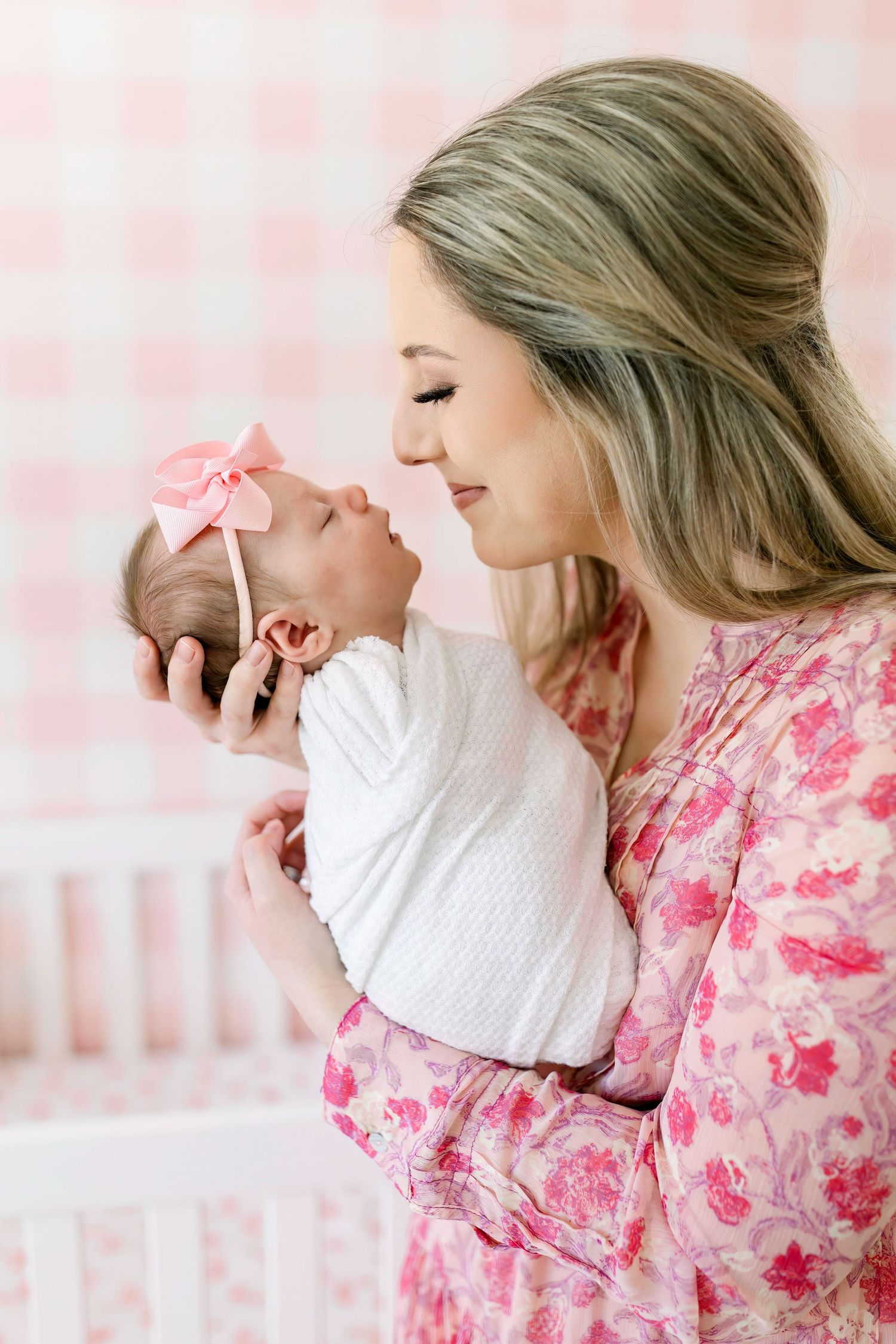 Sweet nurturing moment in pink floral nursery with butterfly decor.