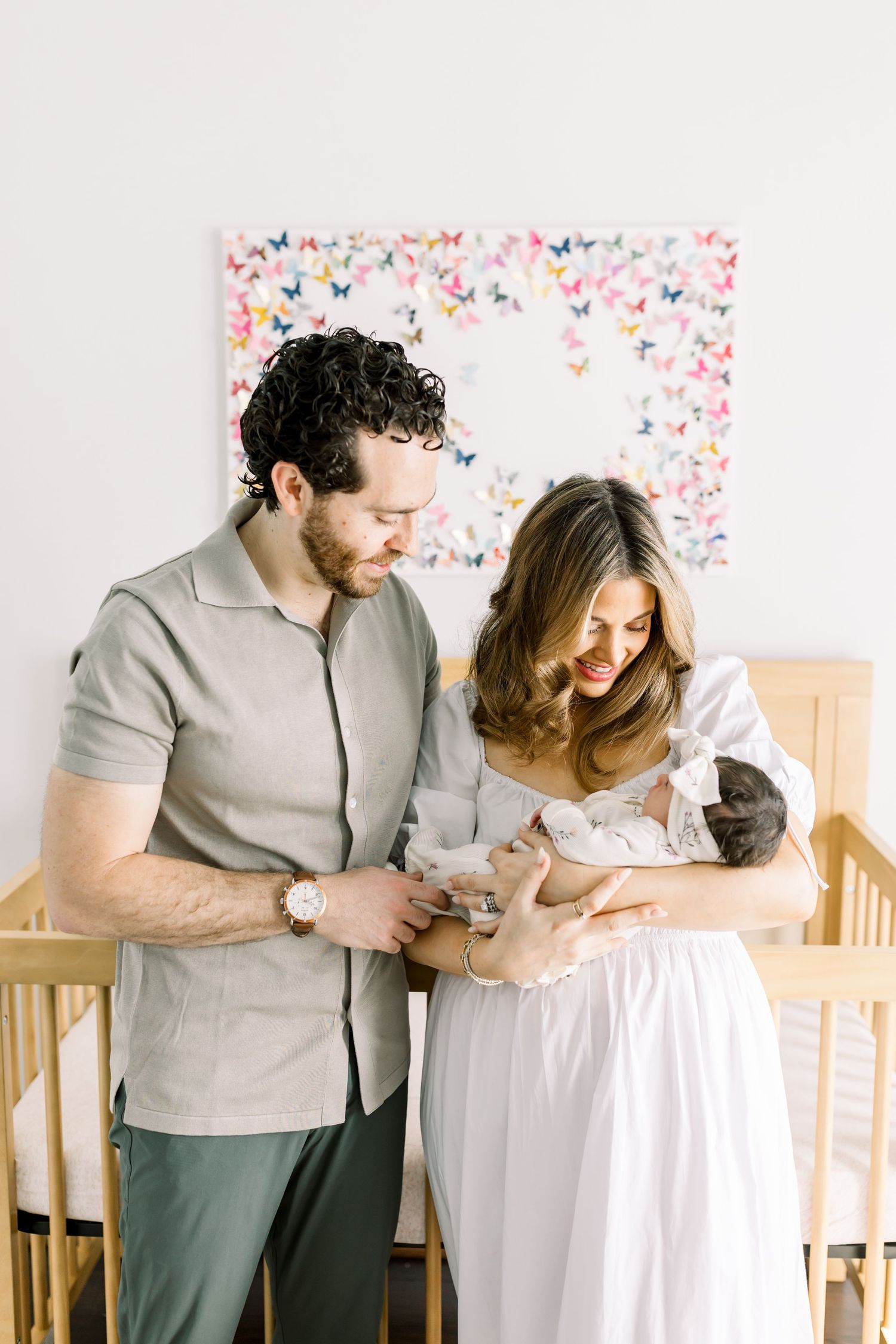 A new family moment in a nursery with their adorable pets watching.