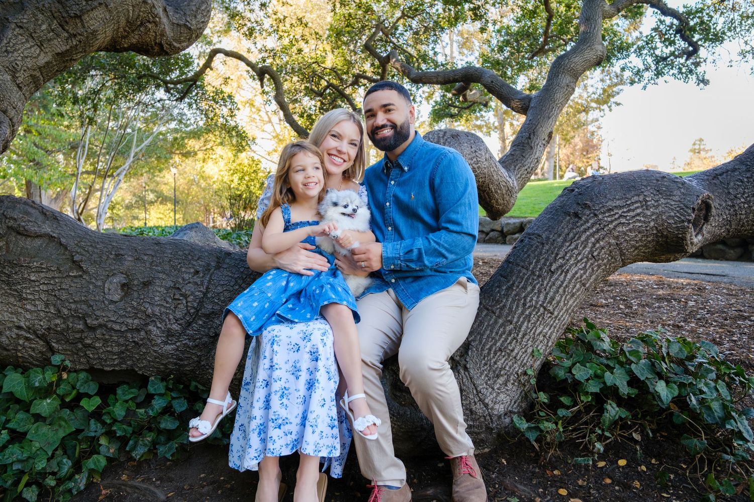 A seaside family portrait featuring casual summer attire and bright smiles.