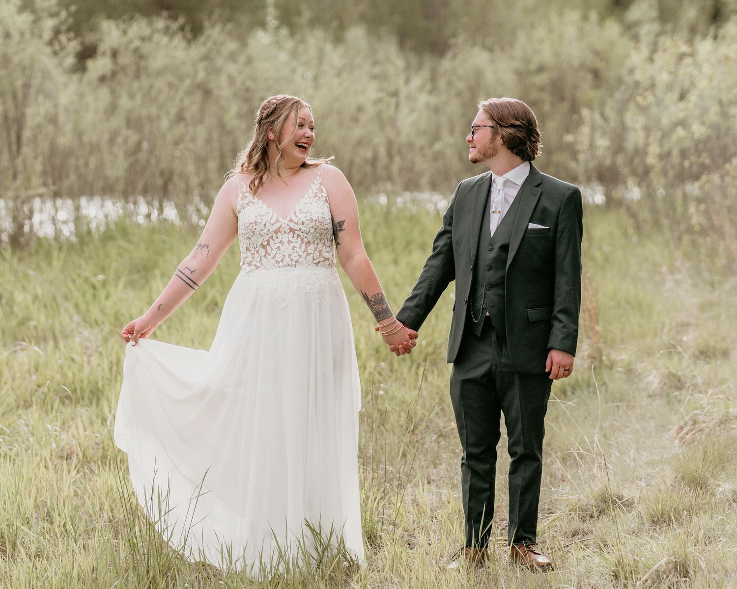 Romantic outdoor wedding portrait in flowing white dress and dark suit.