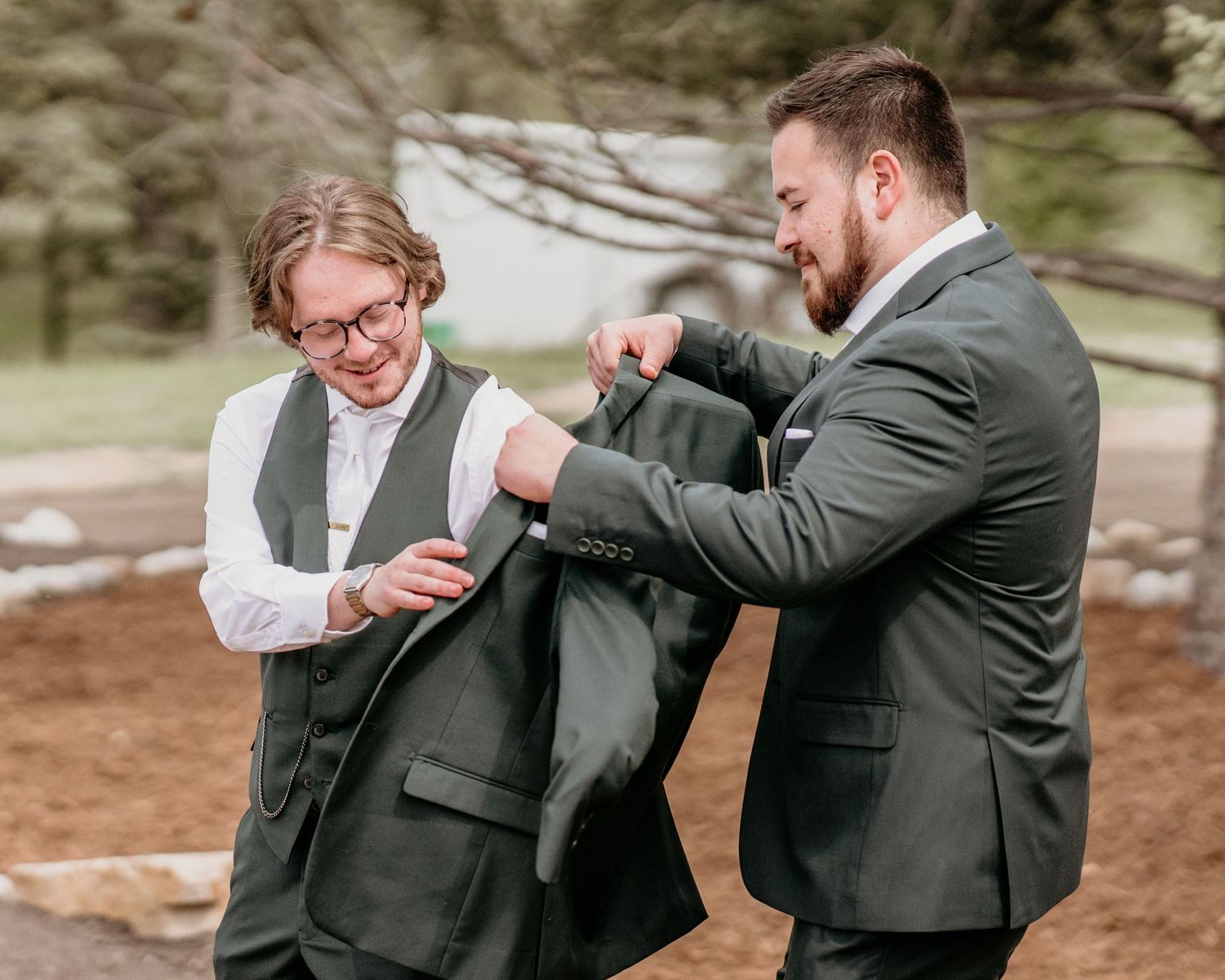 Wedding preparation moment showing adjustments to formal attire. best man groom